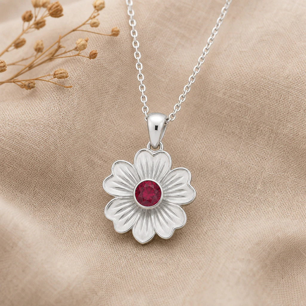 Close-up of silver stock flower pendant with heart shaped petals and round stone