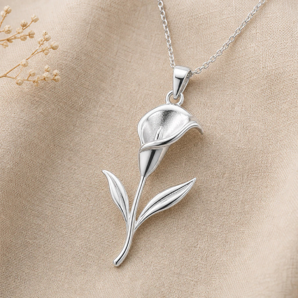 Close-up of silver calla lily pendant with trumpet bloom and two leaves