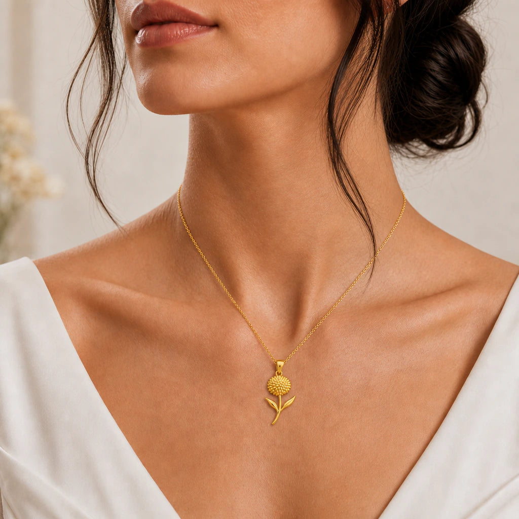 Gold plated allium flower pendant necklace worn by a woman in a white dress