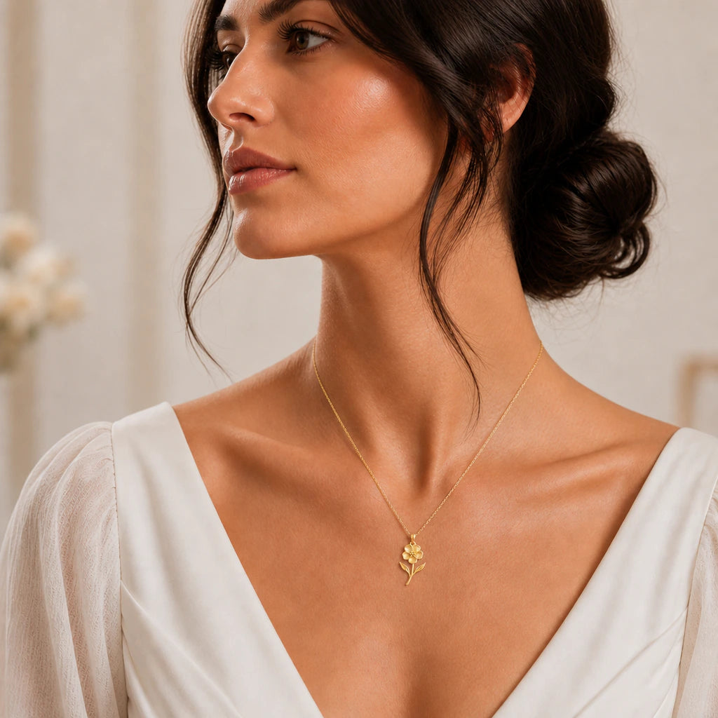 Gold waxflower flower necklace worn with an ivory dress, lifestyle image