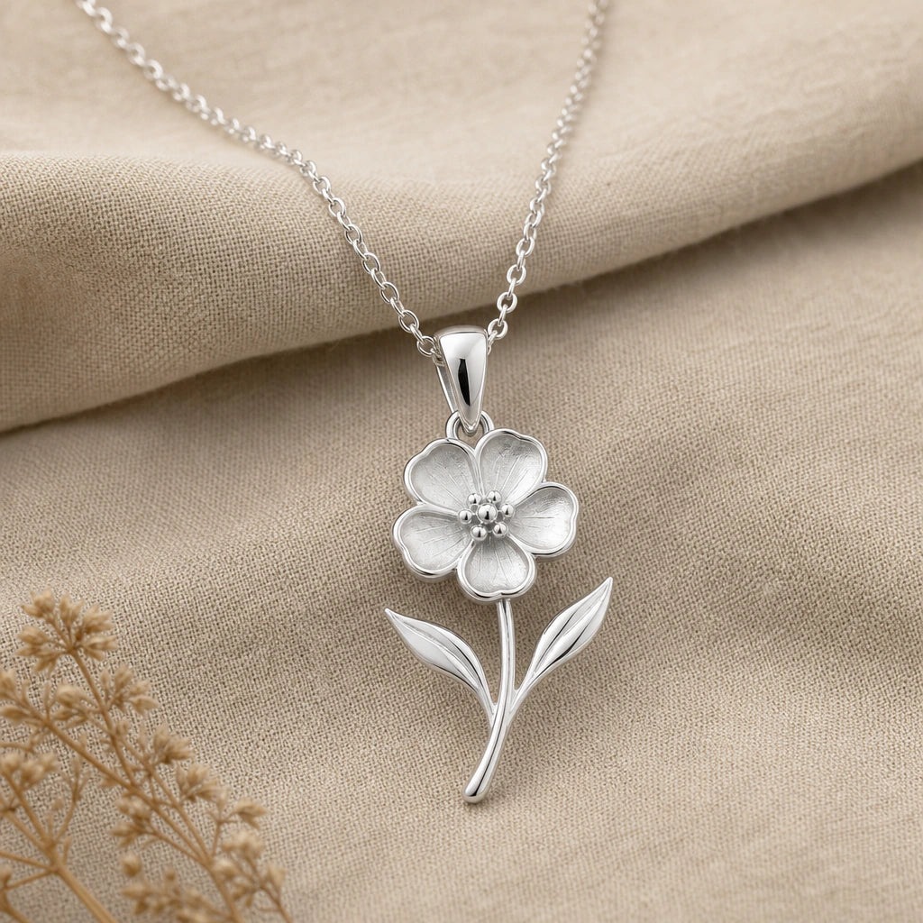 Close-up of silver waxflower pendant necklace with floral centre, stem and leaves