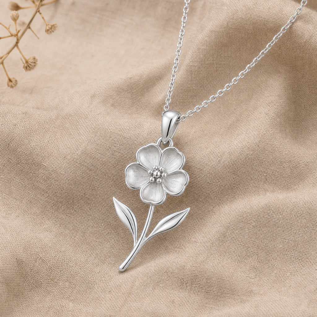 Sterling silver Waxflower Pendant Necklace with five-petal flower and leaf details on neutral linen