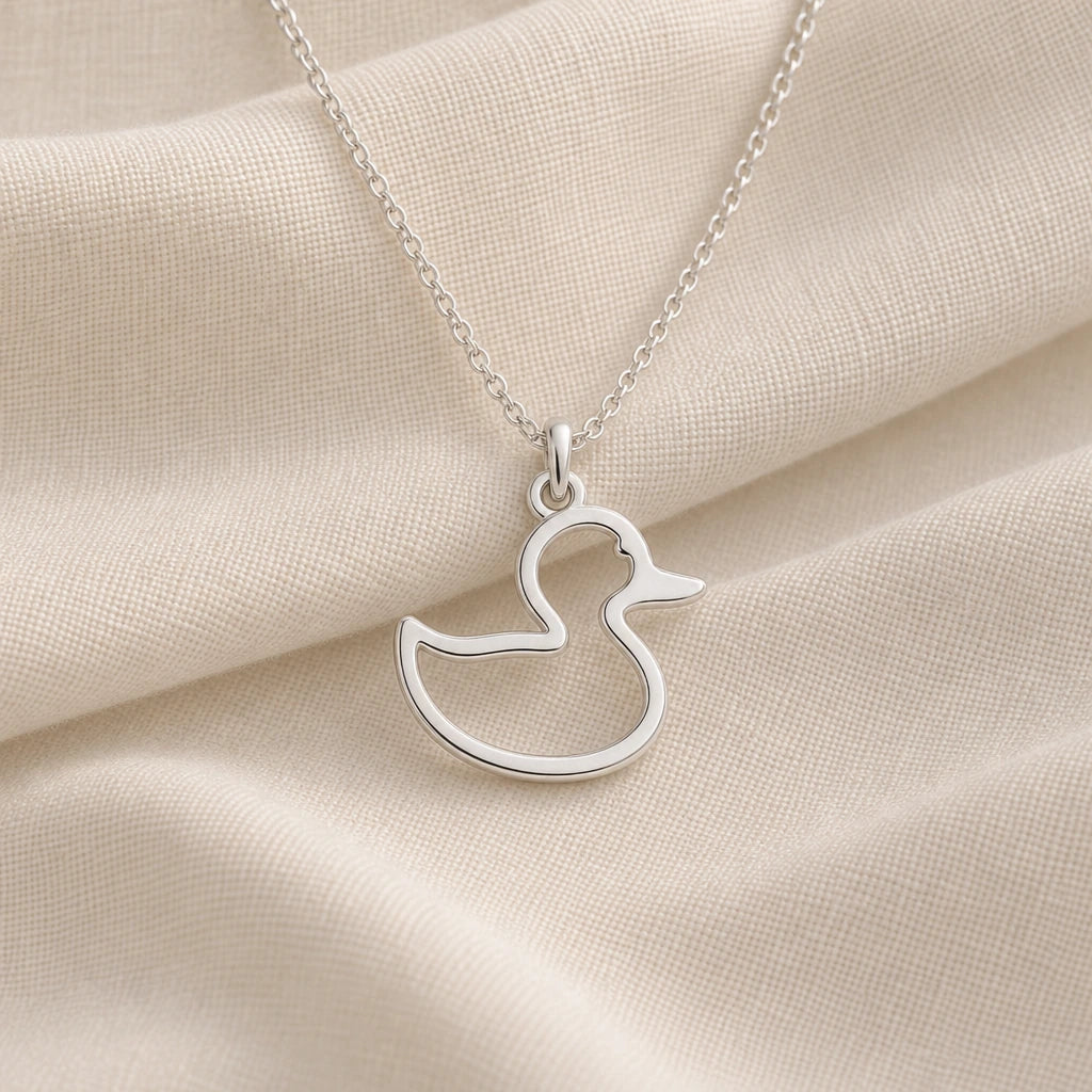 925 sterling silver rubber duck outline pendant necklace on cream fabric