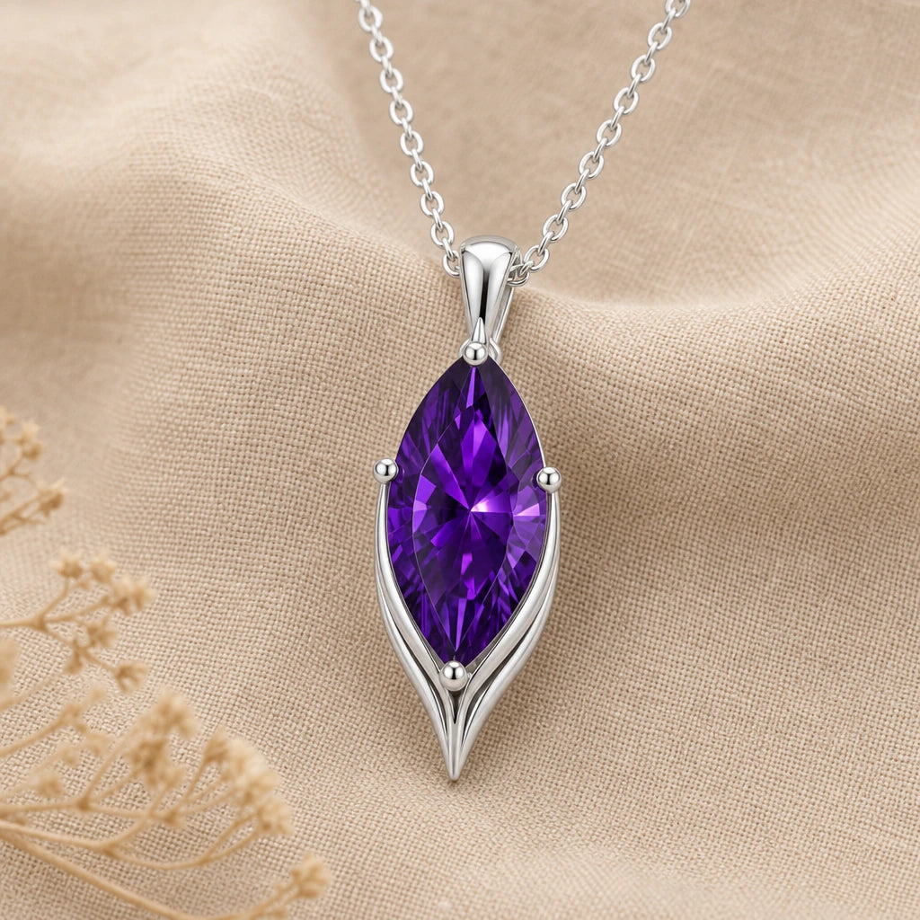 Close-up of silver marquise pendant with claw set stone and pointed base