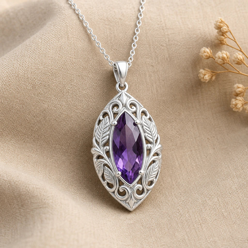 Close-up of silver leaf vine pendant with marquise stone and engraved leaves