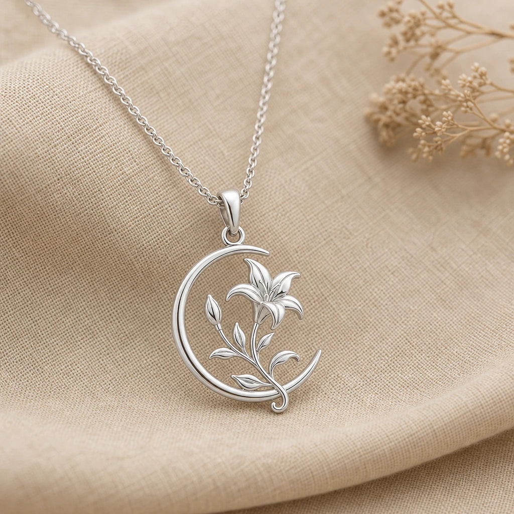 Close-up of silver crescent moon pendant with lily bloom and vine