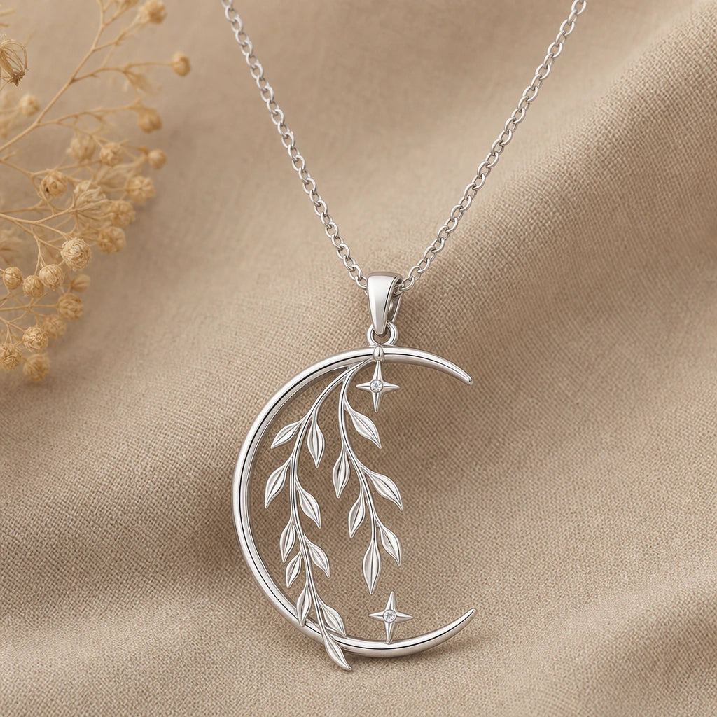 Close-up of silver crescent moon pendant with willow branches and stars