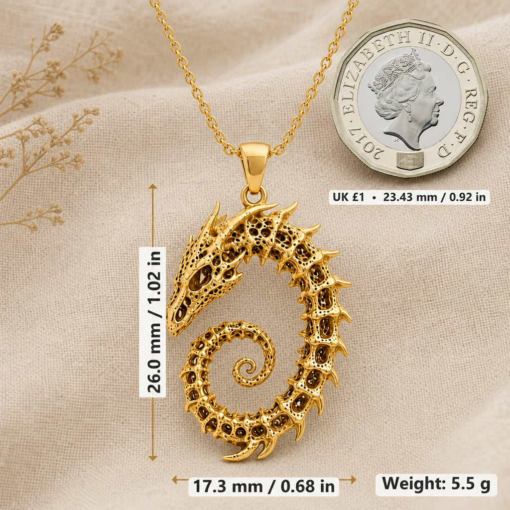 Dragon skeleton necklace size image showing 26 mm height, 17.3 mm width and 5.5 g weight beside a UK pound coin