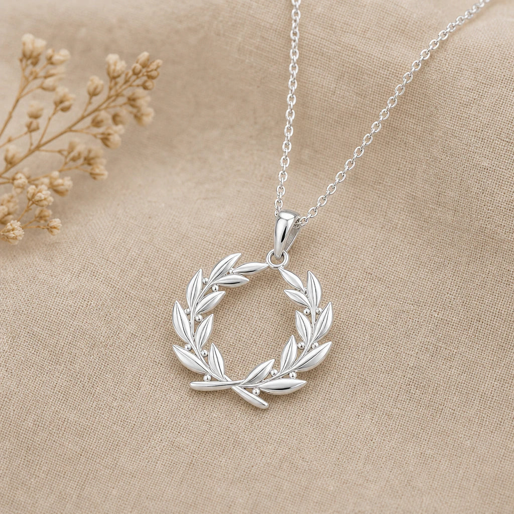 Close-up of silver laurel wreath pendant with leaves and berries