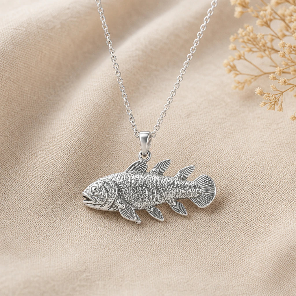 Close-up of silver coelacanth pendant with textured scales and lobed fins