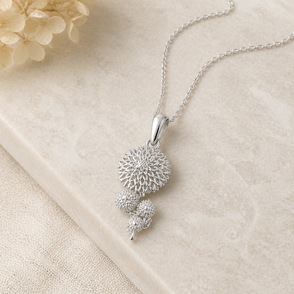 Close-up of silver chrysanthemum flower pendant showing the sculpted detail