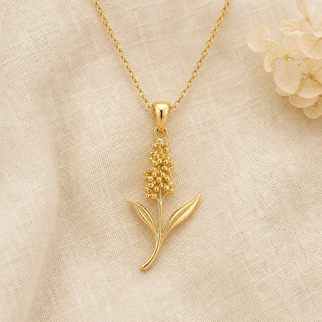 Hyacinth Flower pendant necklace in a warm gold finish on cream fabric