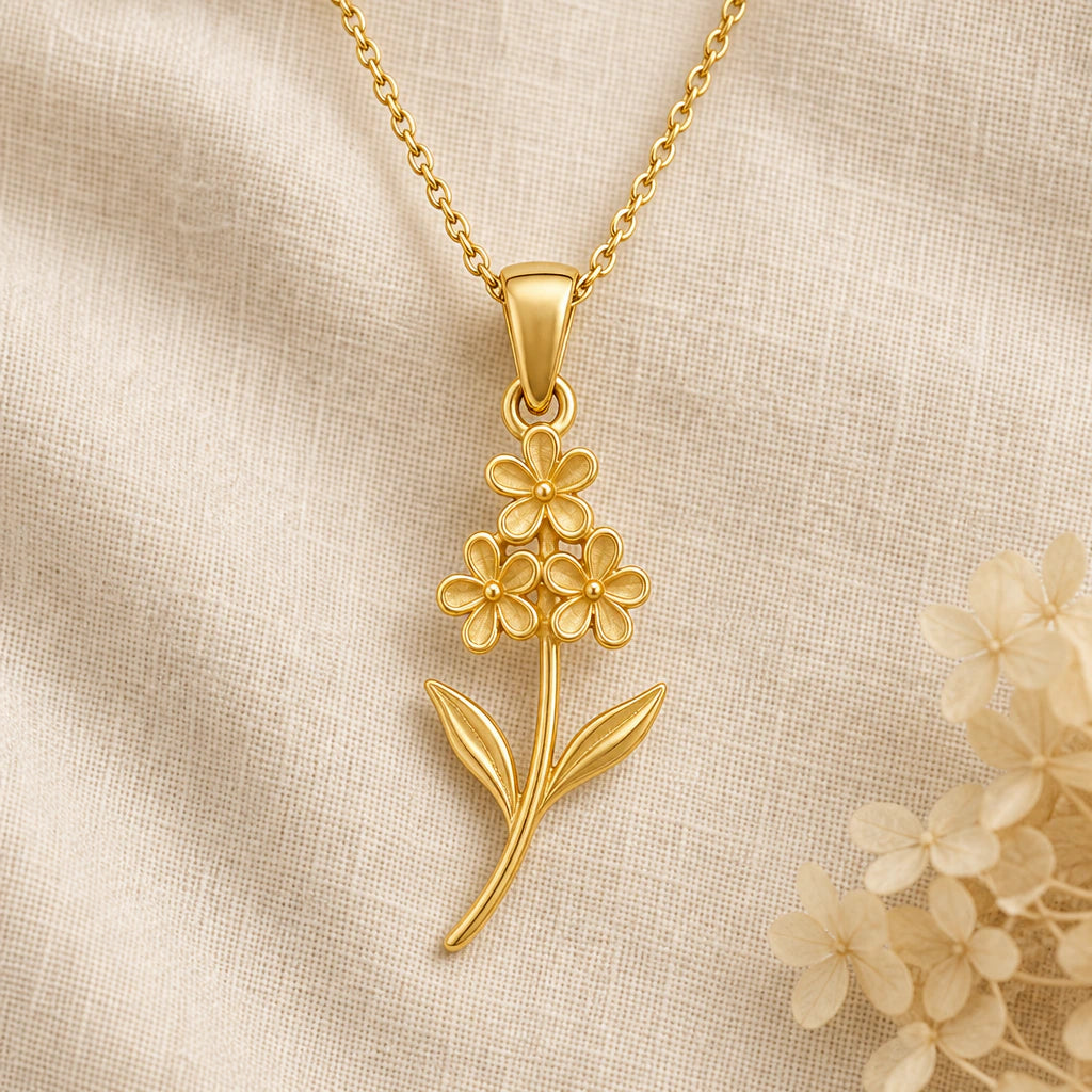 Heather Flower pendant necklace in a warm gold finish on cream fabric