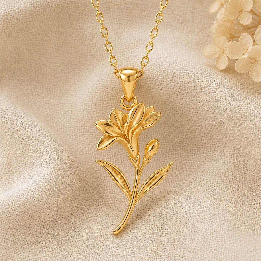 Freesia Flower pendant necklace in a warm gold finish on cream fabric