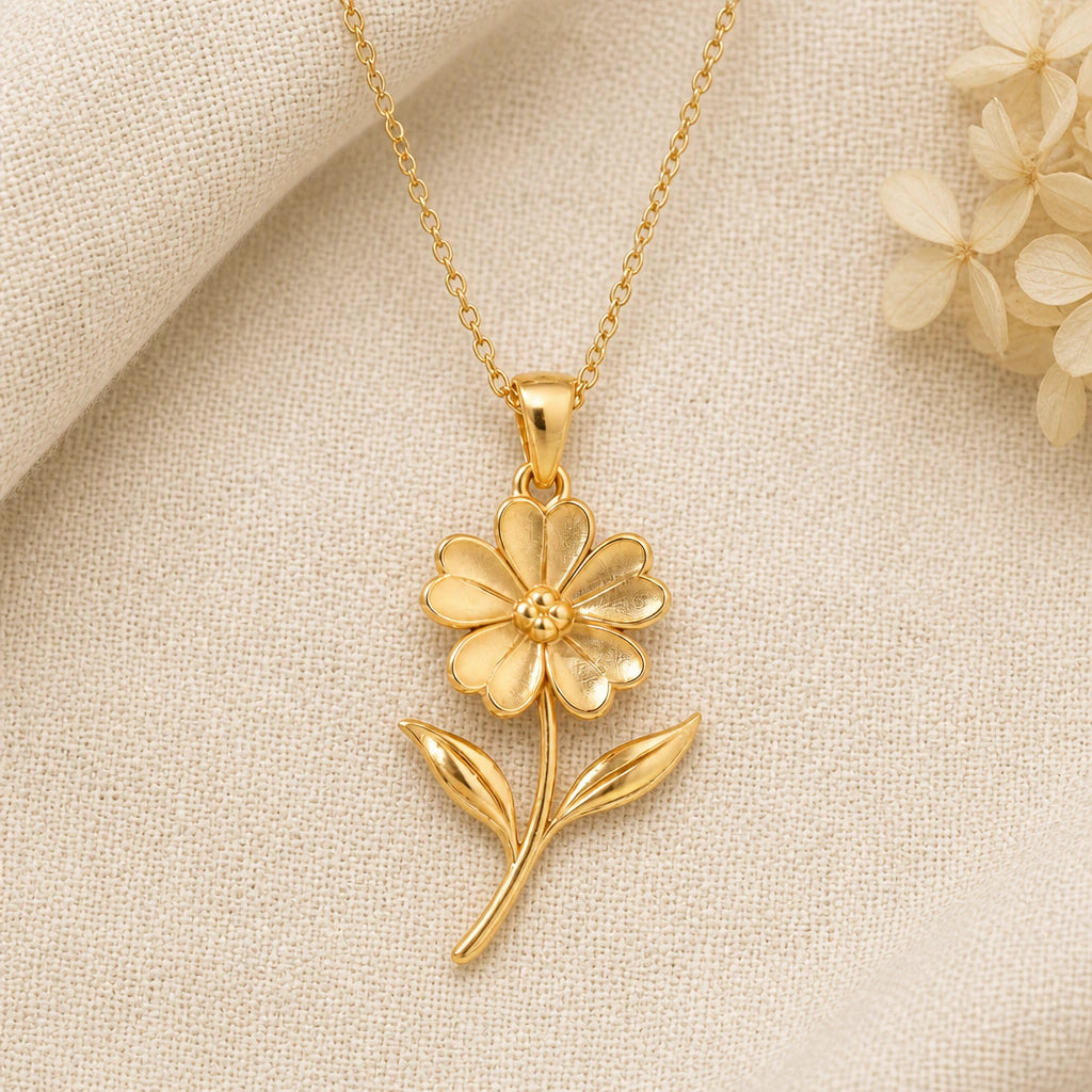 Verbena Flower pendant necklace in a warm gold finish on cream fabric
