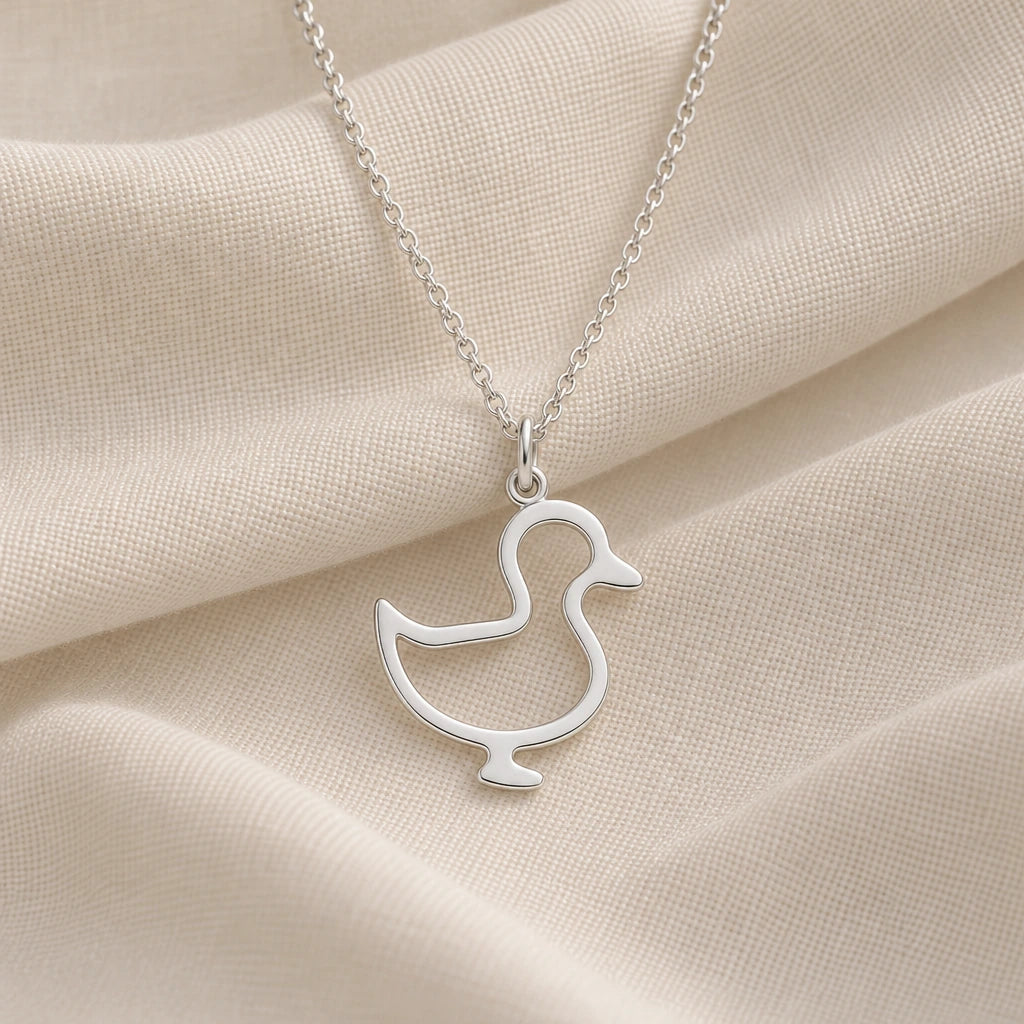 925 sterling silver standing duck outline pendant necklace on cream fabric