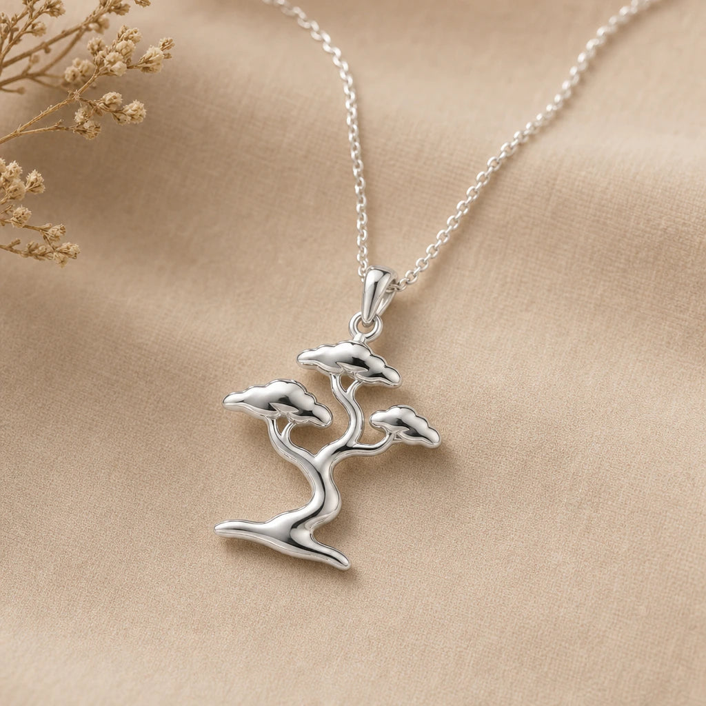 Close-up of silver bonsai tree pendant with twisting trunk and foliage pads