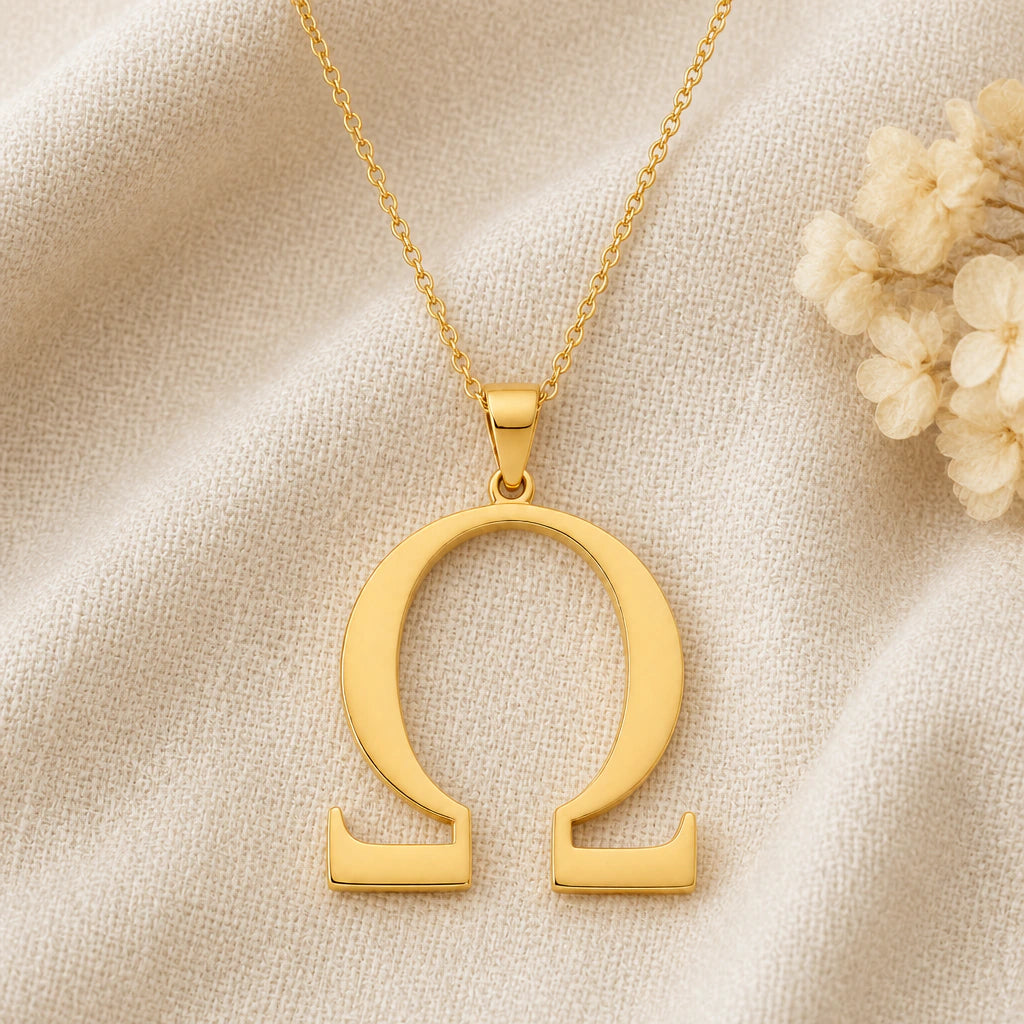 Omega Symbol pendant necklace in a warm gold finish on cream fabric