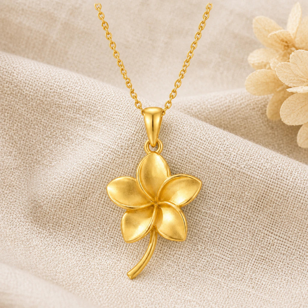 Plumeria Flower pendant necklace in a warm gold finish on cream fabric