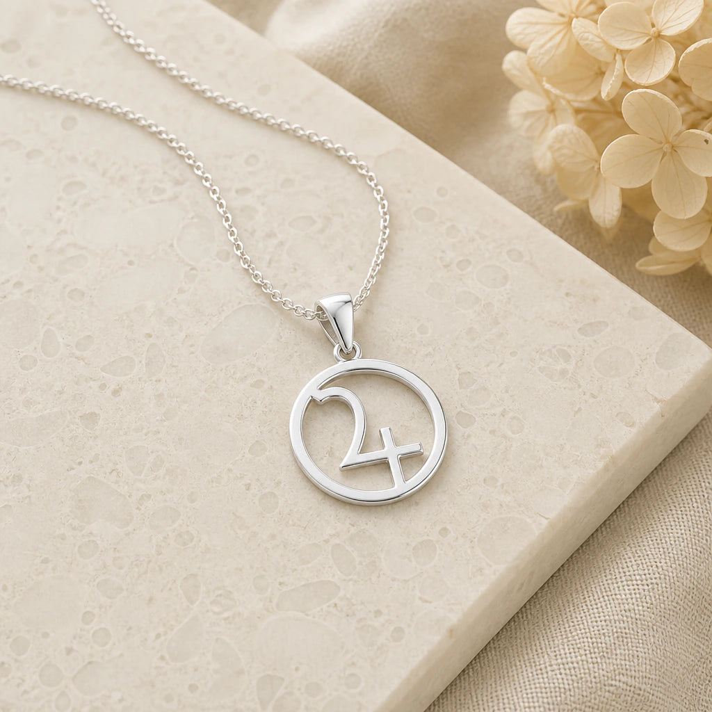 Close-up of silver jupiter symbol pendant showing the sculpted detail