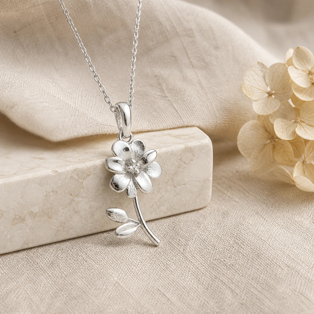 925 sterling silver cosmos flower pendant necklace on softly folded cream linen