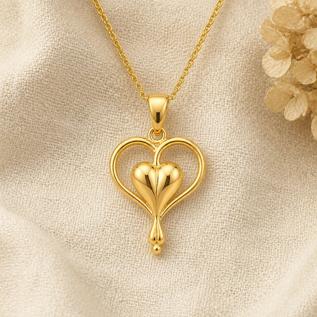 Bleeding Heart Flower pendant necklace in a warm gold finish on cream fabric