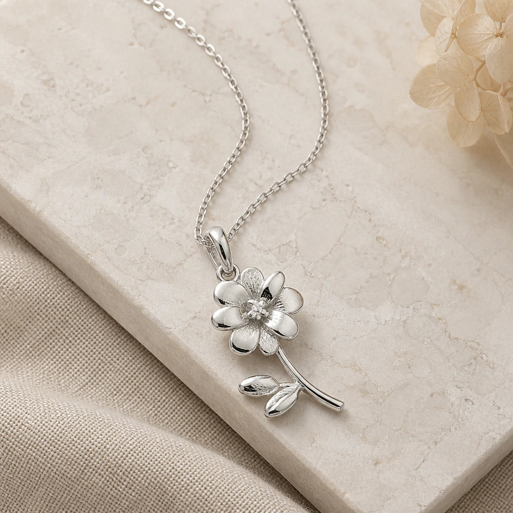 Close-up of silver cosmos flower pendant showing the sculpted detail