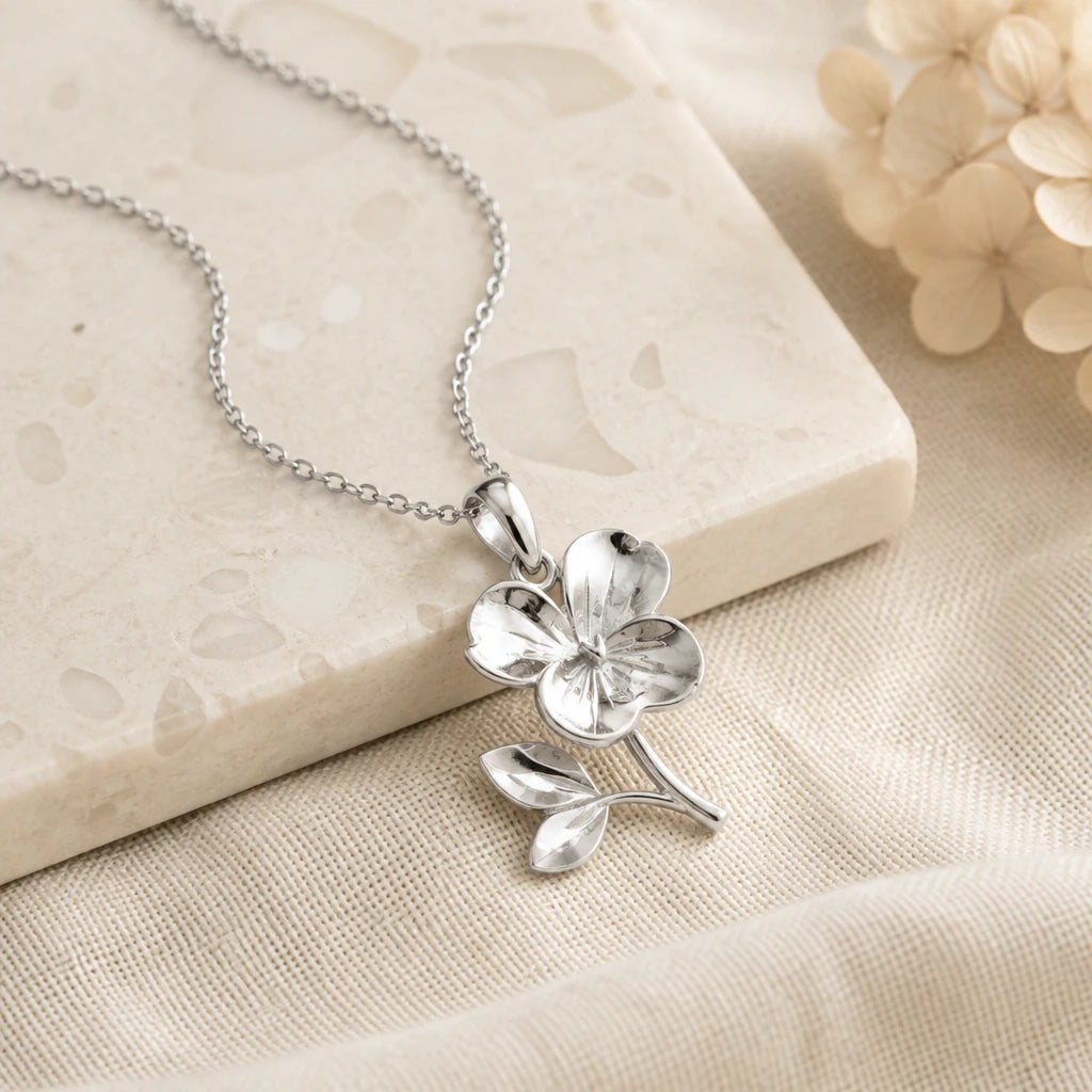 Close-up of silver violet birth flower pendant showing the sculpted detail