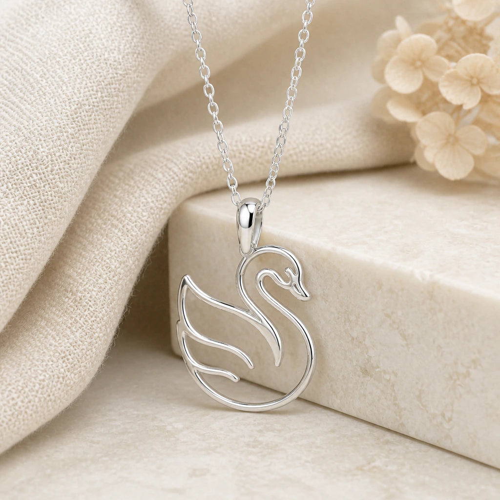 925 sterling silver swan outline pendant necklace on softly folded cream linen