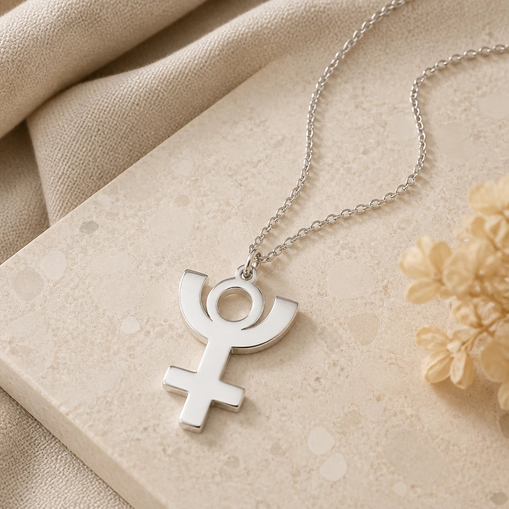 Close-up of silver pluto symbol pendant showing the sculpted detail