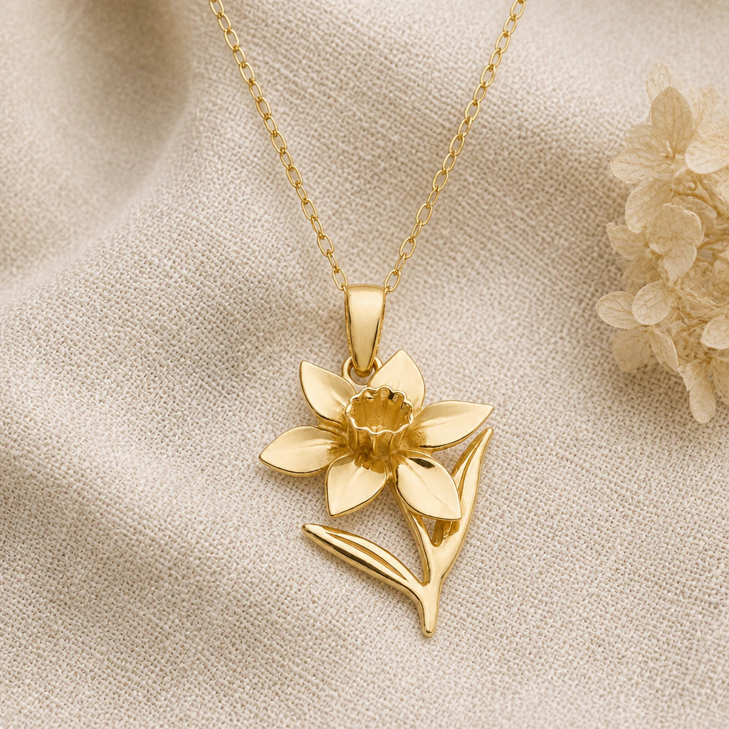 Daffodil Narcissus Flower pendant necklace in a warm gold finish on cream fabric