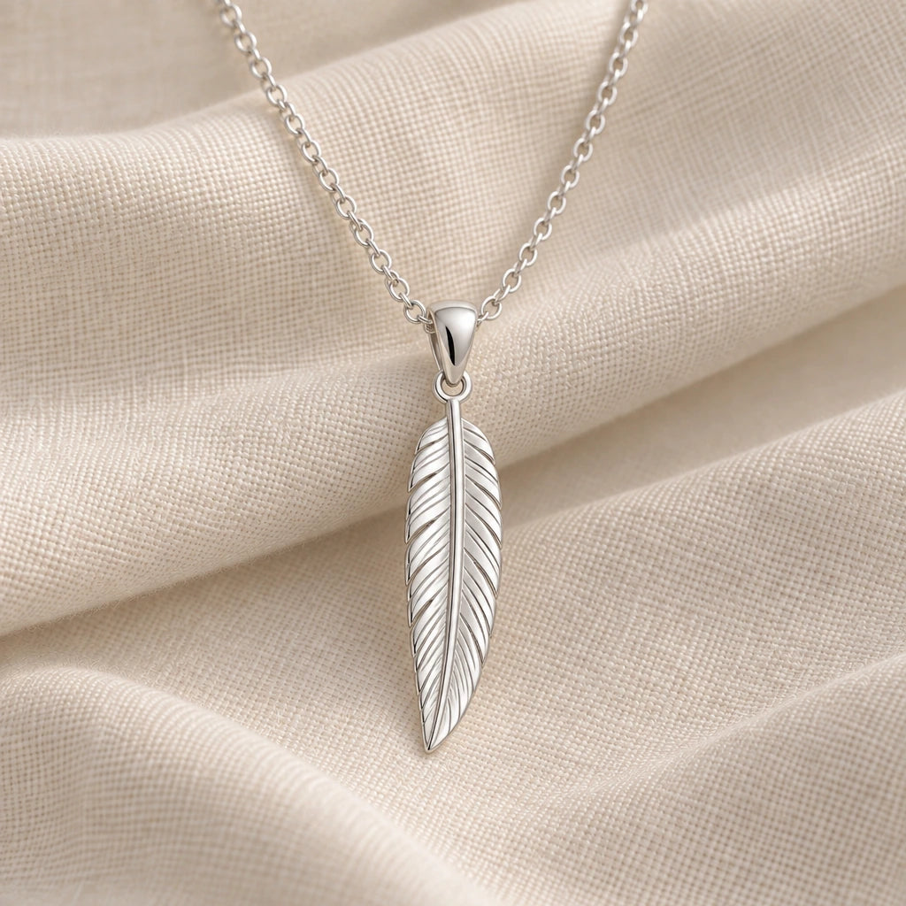 925 sterling silver engraved feather pendant necklace on cream fabric