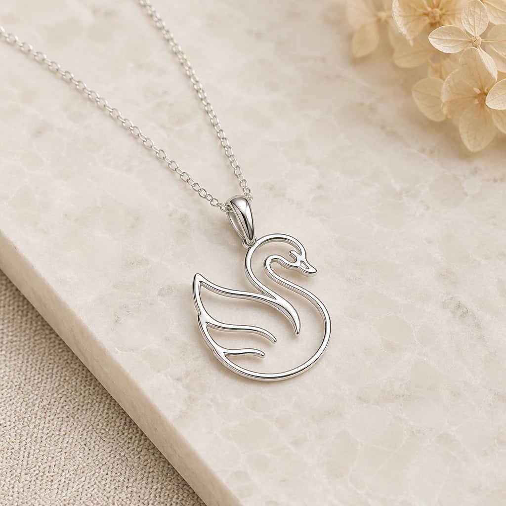 Close-up of silver swan outline pendant showing the sculpted detail