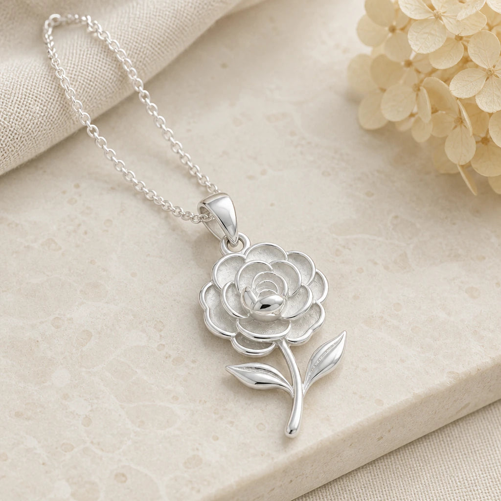 Close-up of silver camellia flower pendant showing the sculpted detail