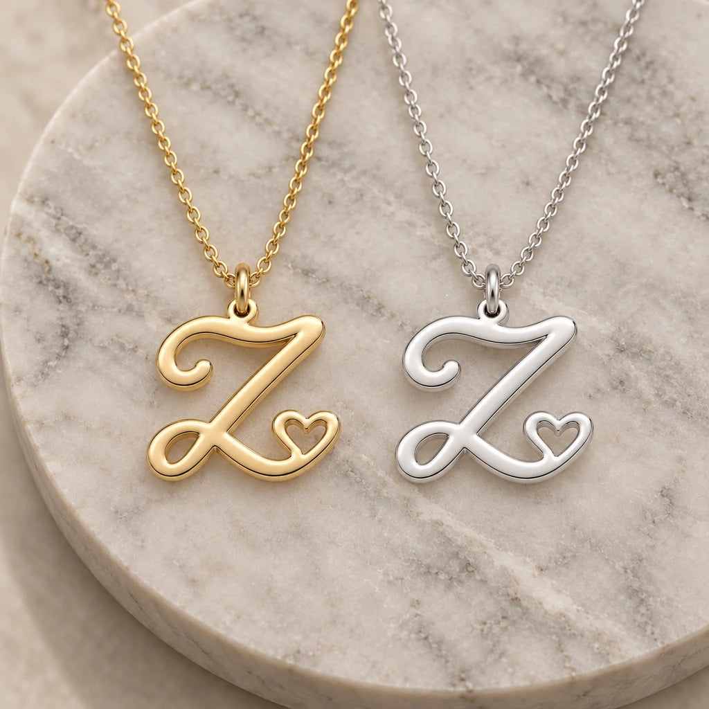 Silver and gold z initial heart pendant necklaces side by side on marble