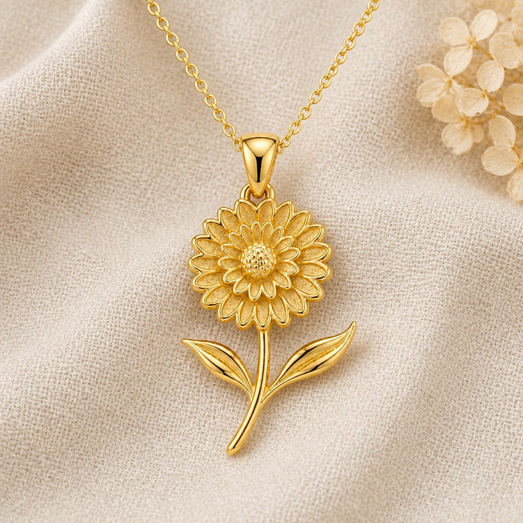 Marigold Bloom Flower pendant necklace in a warm gold finish on cream fabric