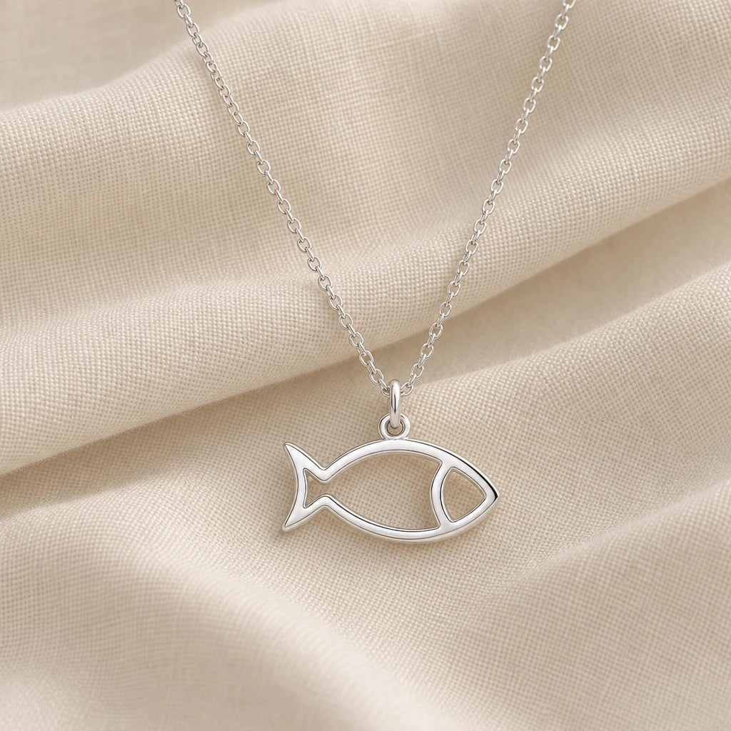 925 sterling silver fish outline pendant necklace on cream fabric
