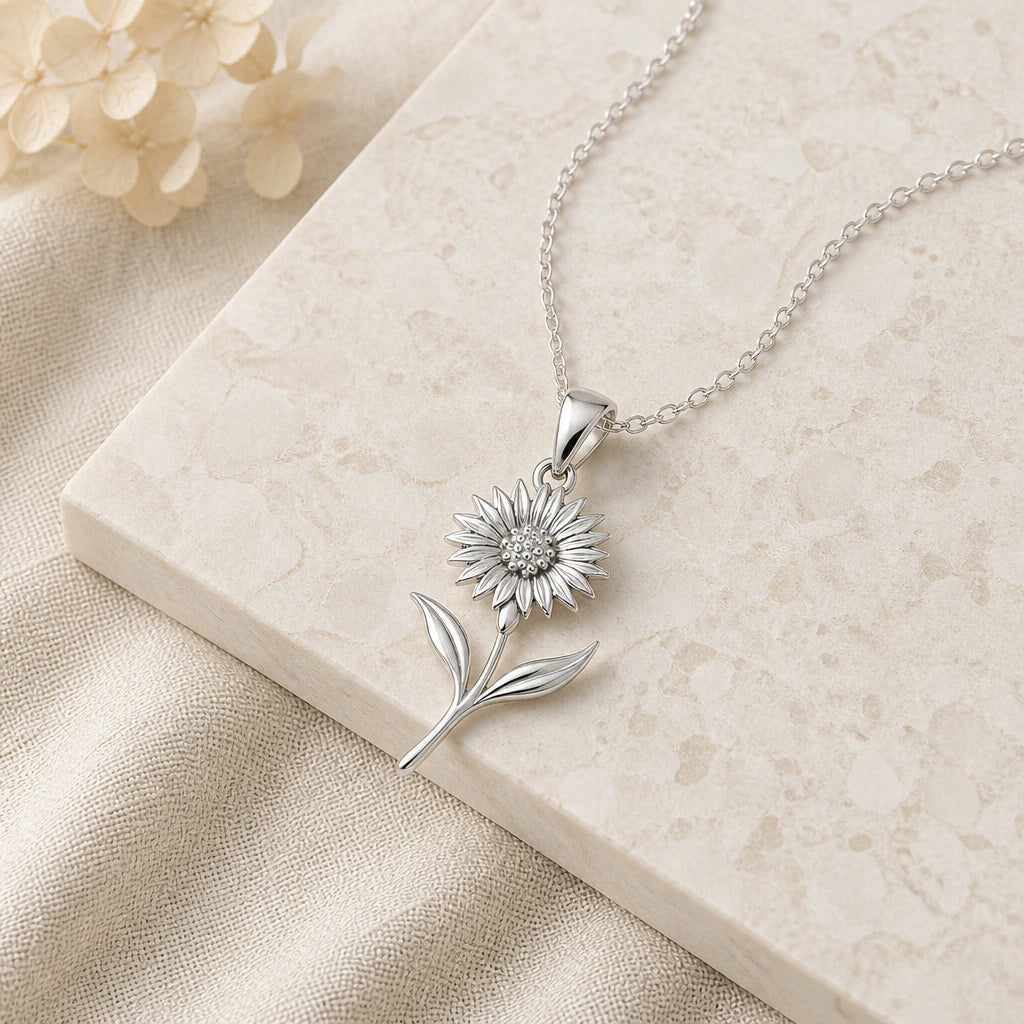 Close-up of silver cornflower pendant showing the sculpted detail