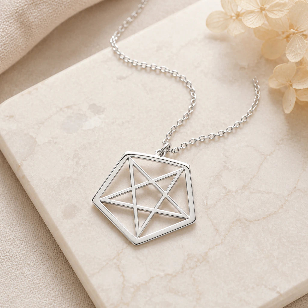 Close-up of silver inverted pentagram pendant showing the sculpted detail