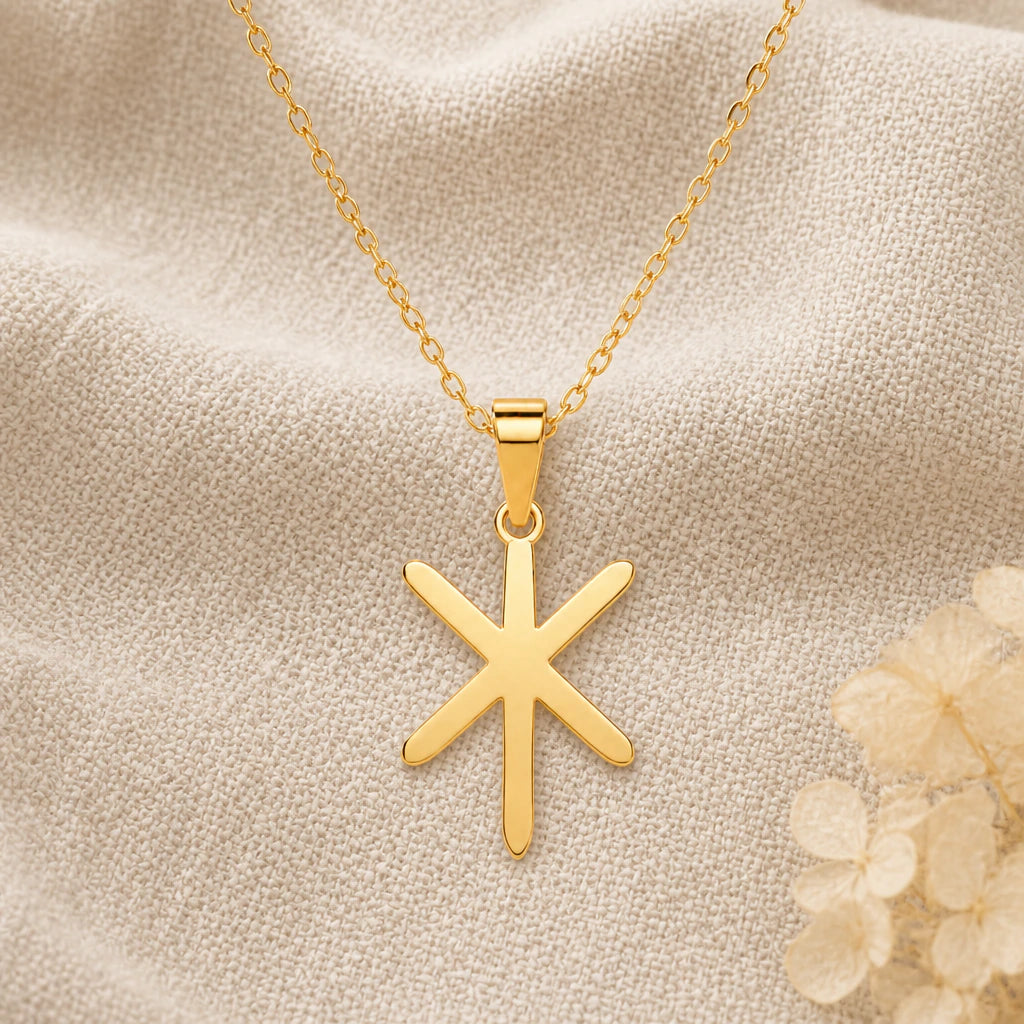 Viking Gebo Isa Bind Rune pendant necklace in a warm gold finish on cream fabric