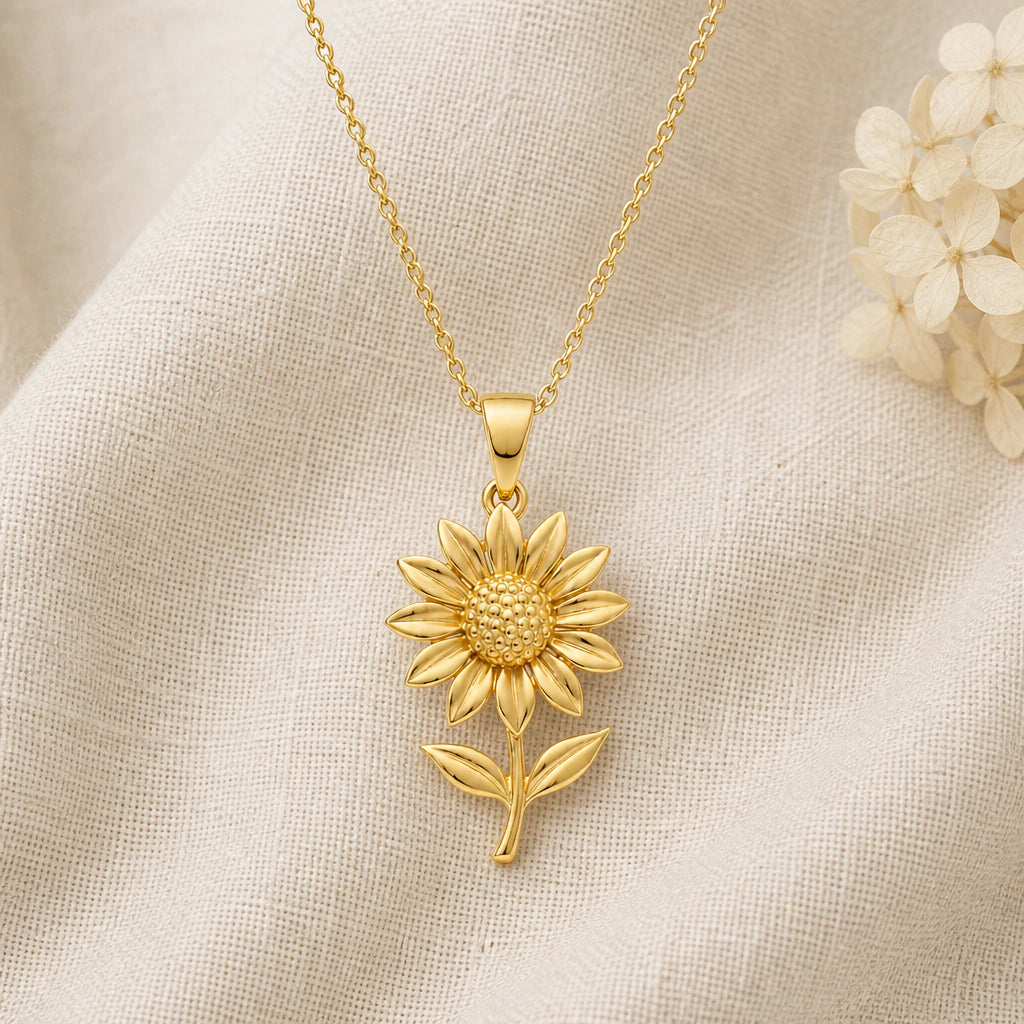 Sunflower pendant necklace in a warm gold finish on cream fabric