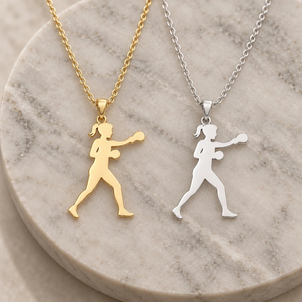 Female Boxer Punch pendant necklace in silver and gold finishes side by side