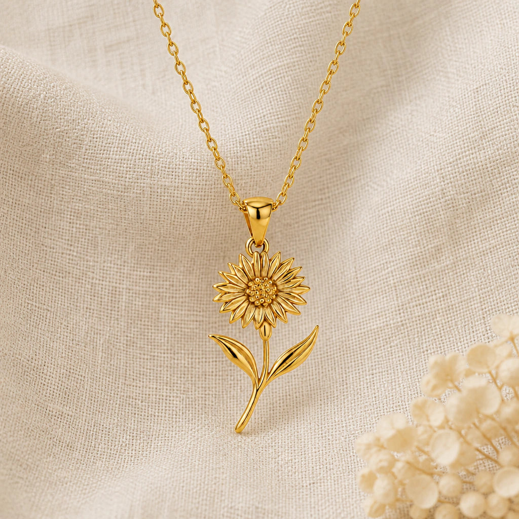 Cornflower pendant necklace in a warm gold finish on cream fabric