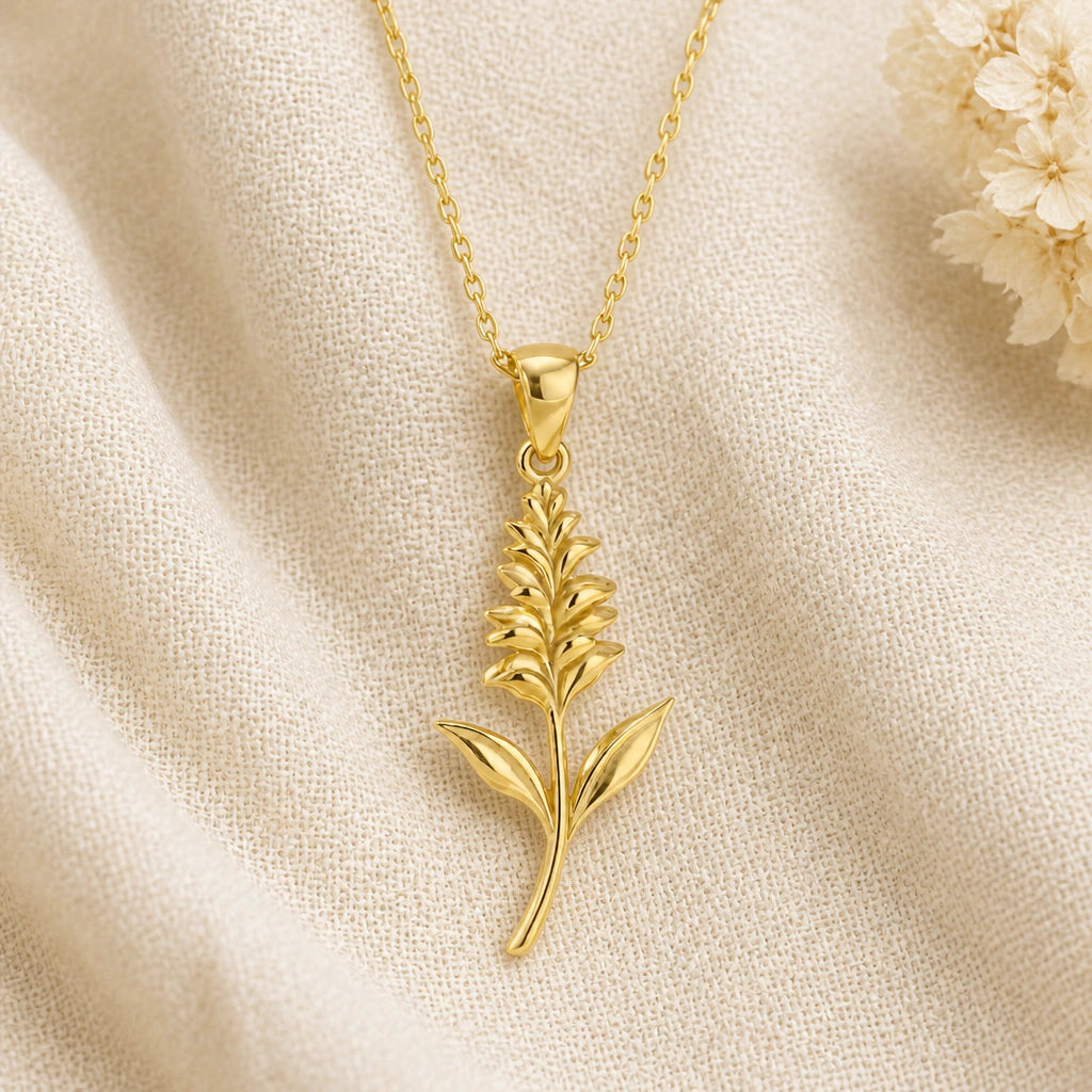 Salvia Flower pendant necklace in a warm gold finish on cream fabric