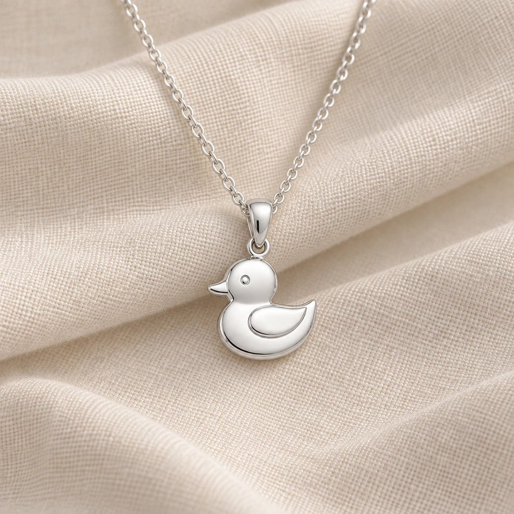 925 sterling silver rubber duck pendant necklace on cream fabric