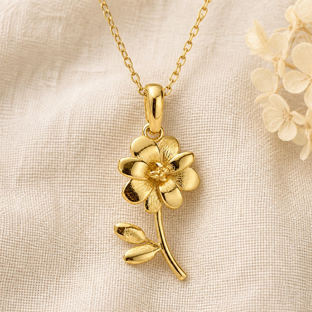 Cosmos Flower pendant necklace in a warm gold finish on cream fabric