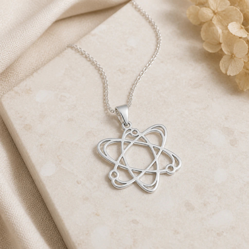 Close-up of silver atom pendant showing the sculpted detail