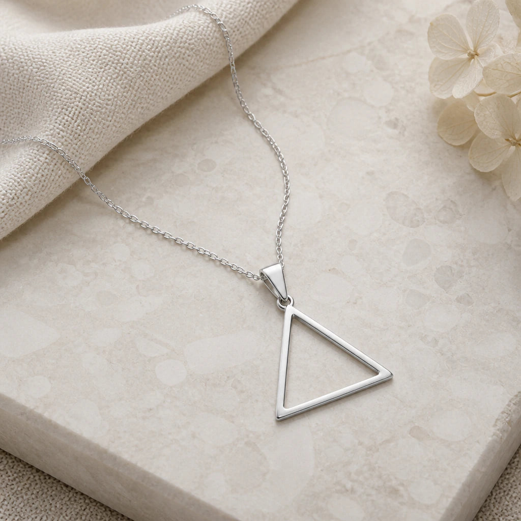 Close-up of silver water element triangle pendant showing the sculpted detail