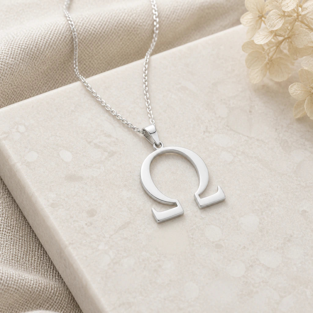 Close-up of silver omega symbol pendant showing the sculpted detail