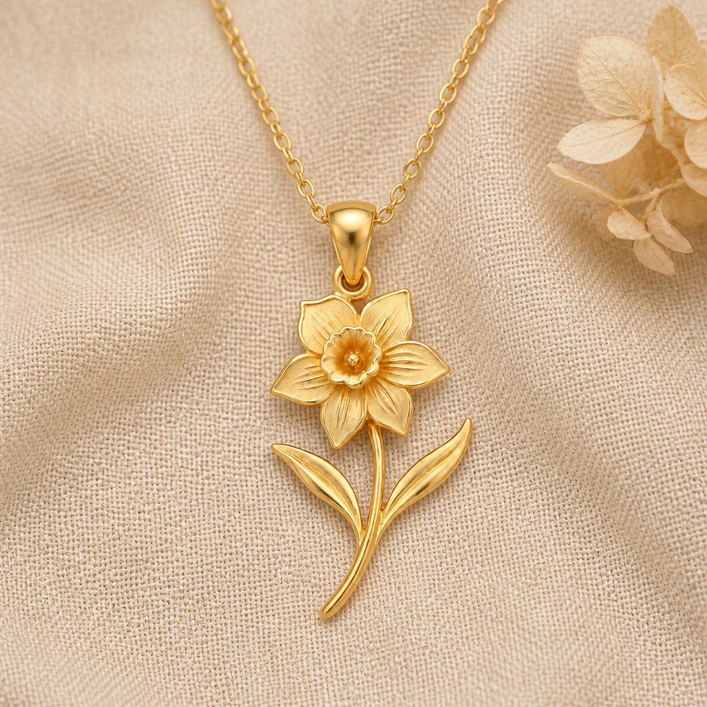 Daffodil Flower pendant necklace in a warm gold finish on cream fabric